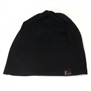 Detailed view of a plain black slouchy knit beanie hat with a small fashion tag design.
