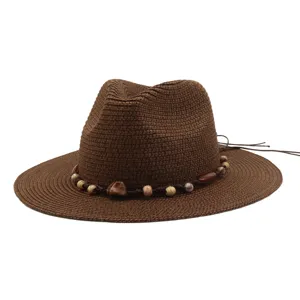 Detail view of the brown straw sun hat showcasing the exquisite beaded band and woven texture.
