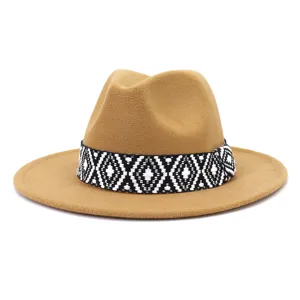 Detalle de un sombrero fedora de lana camello con una banda geométrica tejida en blanco y negro.