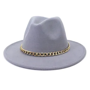 Détail de chapeau fedora en laine grise, orné d'une élégante chaîne métallique dorée.