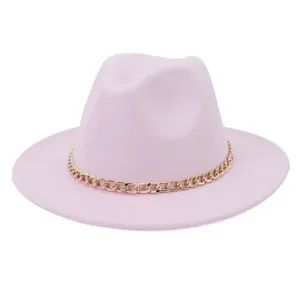 Détail d'un chapeau fedora rose en laine avec une chaîne dorée élégante et large bord.