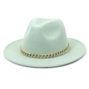 Détail chapeau fedora vert menthe, élégante chaîne dorée, accessoire de mode hivernale.