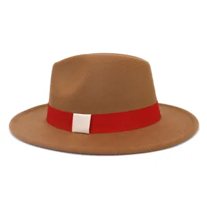 Gros plan du chapeau fedora en laine marron avec un ruban rouge et une boucle blanche.