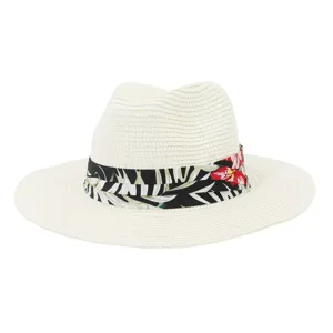 Strohhut Detail: weißer geflochtener Fedora mit tropischem Blattband für den Sommer Strand Sonnenschutz.