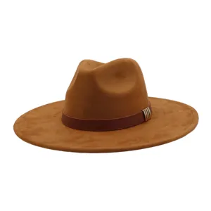 Close-up detail of brown suede fedora hat, featuring dark leather band and metal buckle accent.