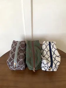 Detailed view of embroidered canvas makeup bags with cute dot circle patterns and zip closure.