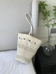 Vista di dettaglio della borsa da spiaggia in macramè fatta a mano con design traforato.