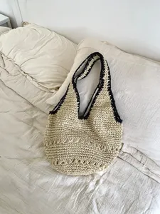 Vue détaillée du sac porté épaule en paille tissée, parfait pour la plage et l'été.