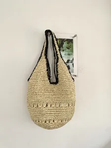 Vue détaillée du sac d'épaule tissé en paille de plage d'été décontracté à bord noir.