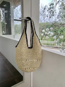 Détail sac épaule paille chic, cabas de plage tissé décontracté avec bordure noire et motif.