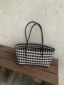 Detailansicht der stilvollen schwarz-weißen geflochtenen Tasche mit schöner Netzstruktur.