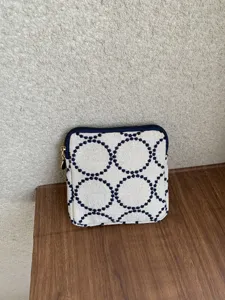 Embroidered fabric coin purse, square zipper makeup pouch with vintage circle pattern detail.