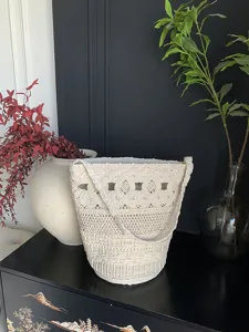 Vista dettagliata della borsa a tracolla in macramè fatta a mano che mostra il motivo intrecciato.