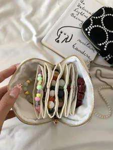 Gedetailleerd overzicht van de geborduurde linnen sieraden opbergtas met meerdere vakken.