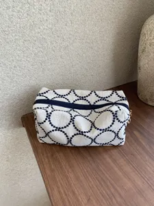 Retro canvas cosmetic bag with dark blue embroidery pattern, portable zipper pouch for daily use.