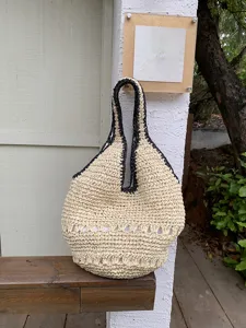 Vue détaillée du sac cabas d'été en paille tissée avec une texture ajourée délicate.