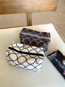 Detailed view of vintage embroidered fabric cosmetic pouch with elegant round dot patterns and zipper.