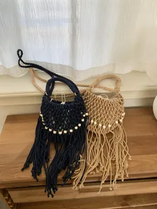 Bellissimo dettaglio della borsa a tracolla intrecciata a mano con nappe e perline di legno.