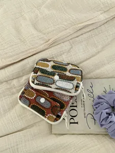 Détail en gros plan du porte-monnaie en toile double couche avec broderie géométrique.