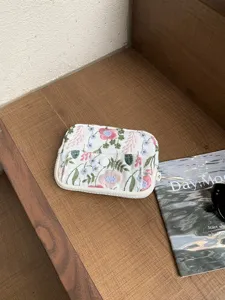 Vue détaillée d'un porte-monnaie en lin et coton brodé de fleurs pour votre usage quotidien.