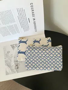 Nahaufnahme der Kosmetiktasche aus Leinen mit Stickerei im stilvollen Flatlay-Design.