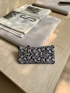 Close-up detail of the exquisite floral embroidered portable storage pouch and glasses case.