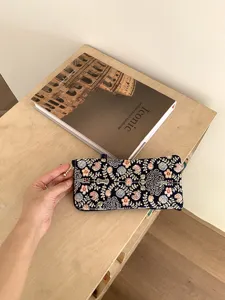 Close-up view of the exquisite floral embroidered pattern on the fabric glasses pouch surface.