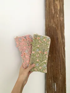 Close-up detail of exquisite floral embroidered zipper pouch, perfect for storing glasses securely.