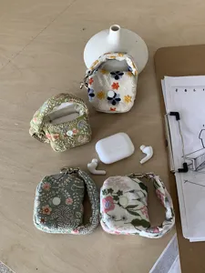 Detailed view of handmade floral embroidered mini pouch with snap button and metal hook.