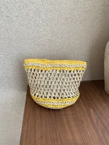 Bolsa de cosmeticos tejida a mano con diseño amarillo y blanco, detalle de estuche portátil.