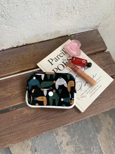 Vue détaillée de la petite pochette en coton brodé pour cartes et monnaie avec double fermeture.