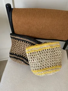 Vista detallada de la bolsa cosmética tejida a mano, textura calada con cierre de cremallera.