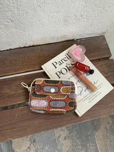 Porte-monnaie brodé en coton et lin avec double compartiment pour cartes et accessoires.