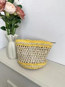 Detalle de neceser tejido a mano, bolsa de almacenamiento de rafia calada con cremallera.