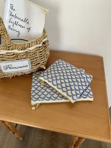 Detailansicht der blauen Kosmetiktasche mit feiner Stickerei und elegantem goldenem Reißverschluss.