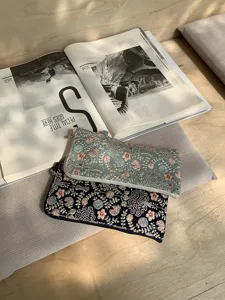Detailed view of exquisite floral embroidered zip pouches showcasing fine craftsmanship and retro style.
