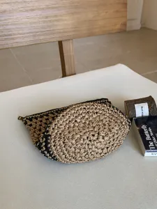 Detalle de bolso de maquillaje tejido a mano, material natural con cierre de cremallera.