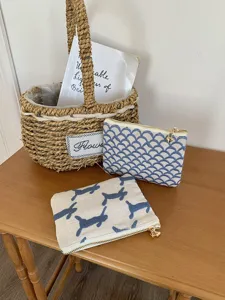 Detailansicht der bestickten Canvas-Reißverschlusstasche mit blauem Muster, kompakte Kosmetiktasche.
