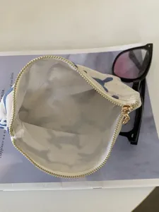 Stofftasche mit Reißverschluss und blauer Stickerei, perfekt für Kosmetik und Kleinteile.