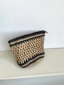 Vista detallada de bolsa de maquillaje tejida a mano con cierre de cremallera.