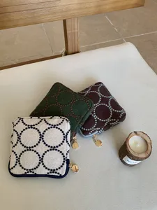 Detailed shot of embroidered fabric coin purse and makeup pouch with unique circle design.