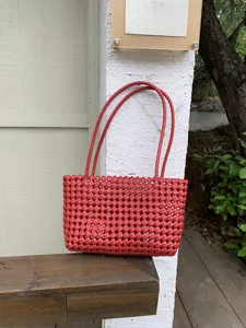 Red woven plastic beach tote bag, hollow out grid basket design, perfect for summer vacation.