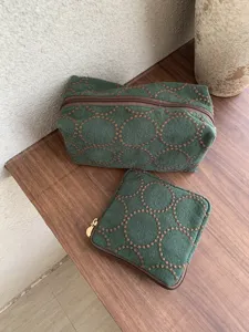 Close-up display of embroidered fabric cosmetic bags featuring elegant circular patterns.