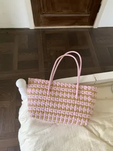 Detailaufnahme der rosa-braunen geflochtenen Tasche, zeigt das Muster und die Henkel.