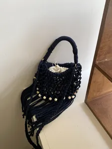 Borsa a tracolla intrecciata cava fatta a mano con nappe e perline di legno per la spiaggia.