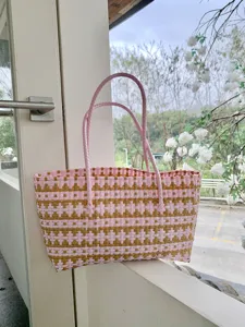 Detailansicht der rosa-goldenen geflochtenen Korbtasche mit feiner Textur und stabilen Griffen.