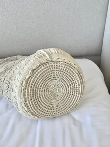 Dettaglio borsa a secchiello intrecciata a mano, consistenza beige per vacanze.