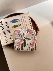 Detail van geborduurde linnen sieradentas, kleine vierkante tas met rits voor ringen.