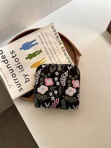 Gedetailleerde close-up van prachtig bloemenborduurwerk op zwart linnen sieradenetui, netjes.