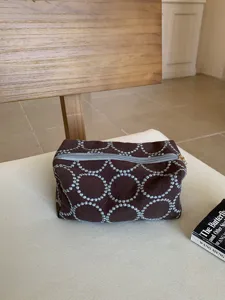 Vintage brown embroidered cosmetic bag with blue circle pattern, retro canvas storage pouch.